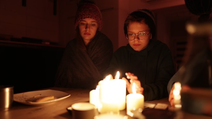 停电期间，一家人坐在蜡烛旁。