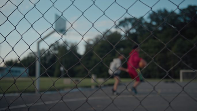 两个十几岁的男孩在黄昏打篮球