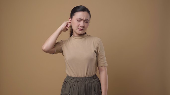 女人痒了，把手指伸进耳朵里。