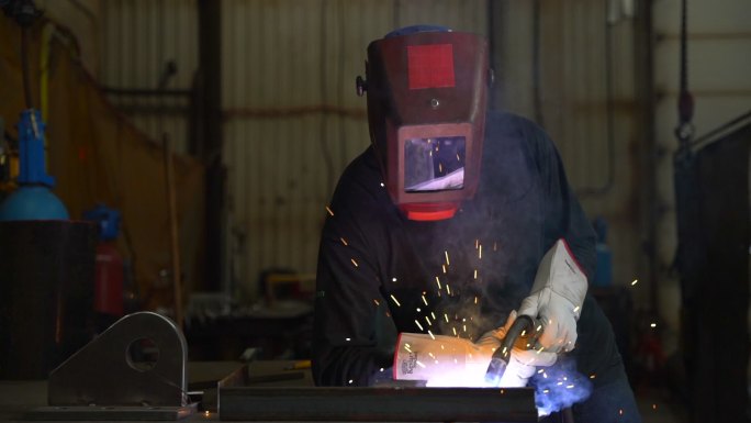 焊工的视频肖像。火星四射钢铁行业加班电焊