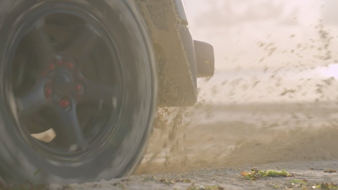 SUV车轮溅起的水和沙子。海滩之旅，特写