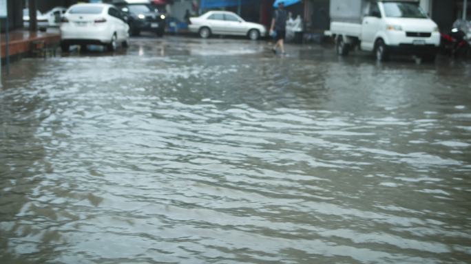 多莉在曼谷的山洪中拍摄了洪水淹没的房屋、汽车和街道，慢镜头