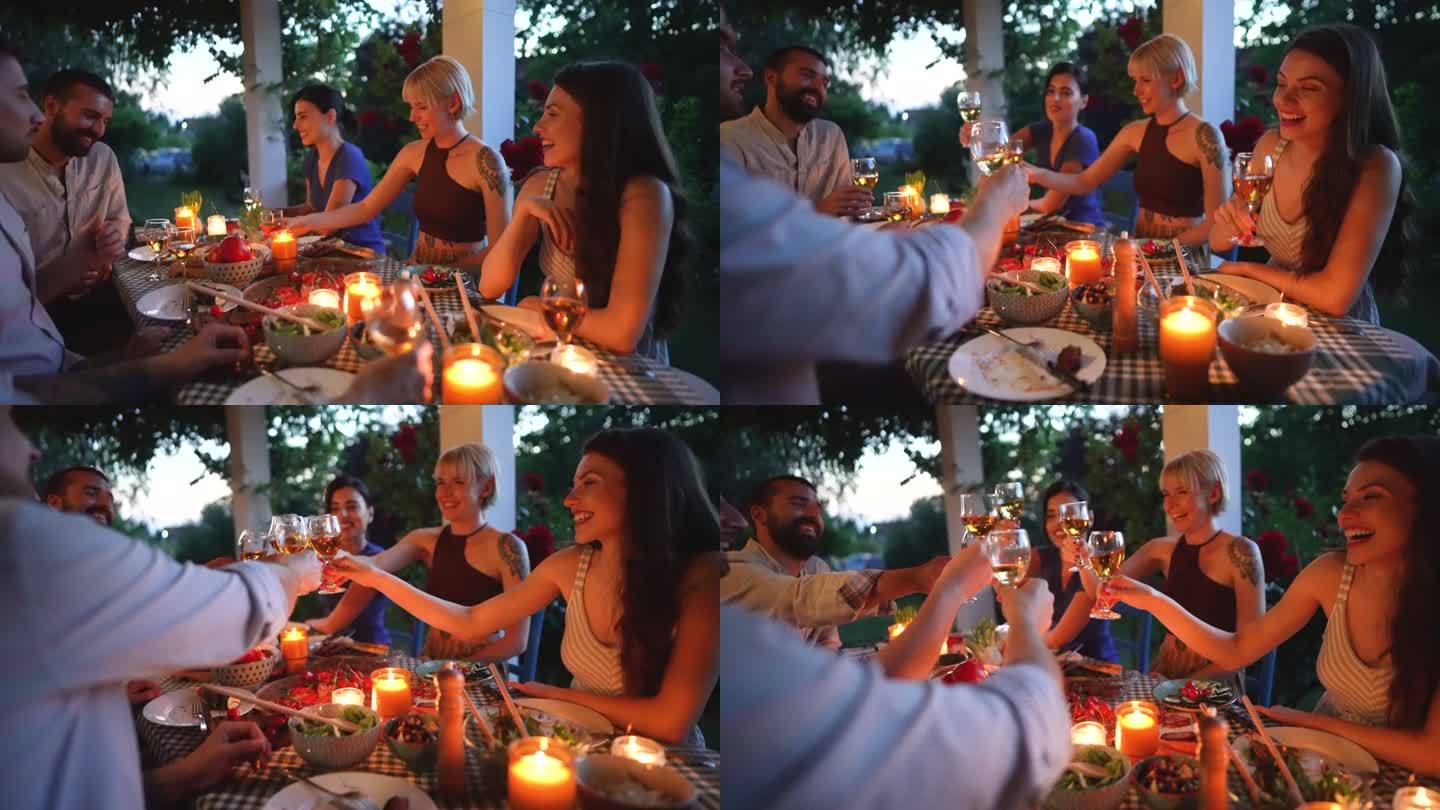 在他们的晚宴上，一群快乐的朋友用白葡萄酒敬酒
