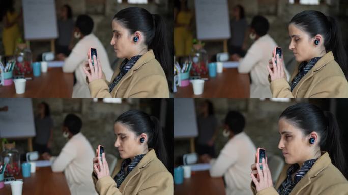 视障女商人在商务会议中使用智能手机和耳机