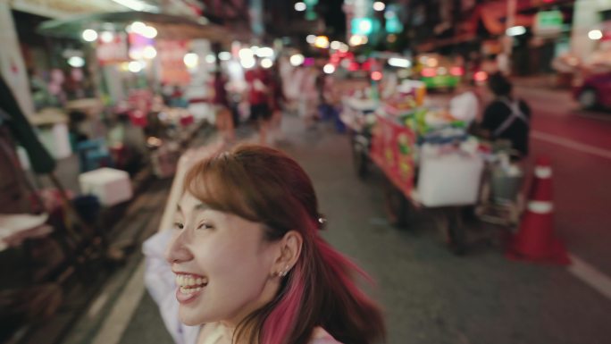 一名年轻女子在泰国夜市拍摄视频博客自拍