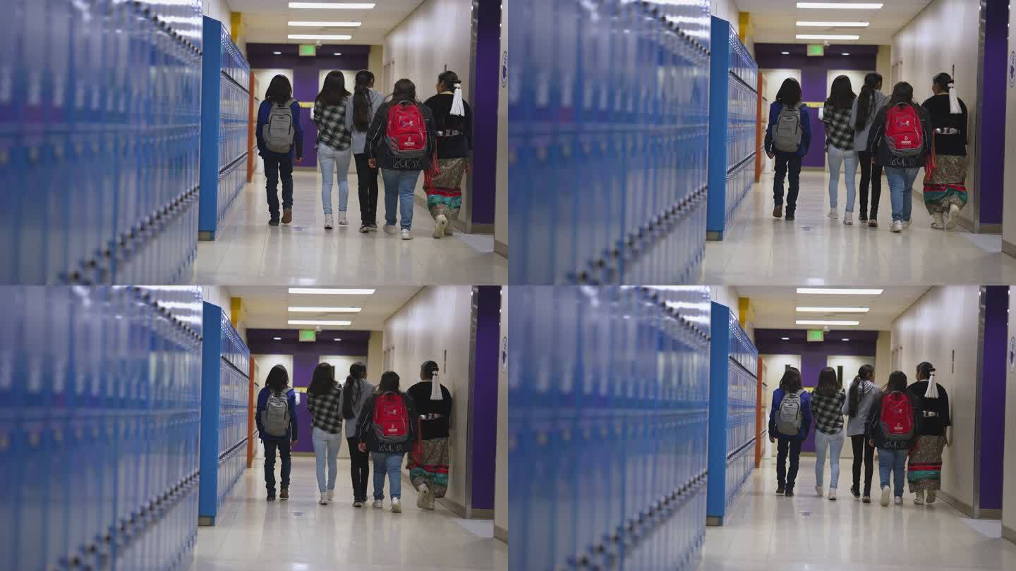一群中学生和高中生穿过学校走廊