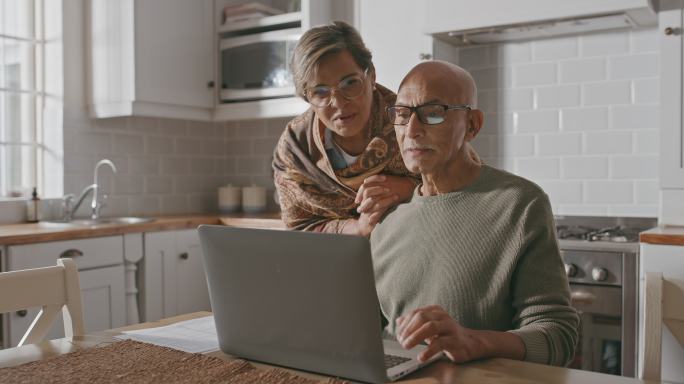 一对老年夫妇在家使用笔记本电脑的4k视频片段