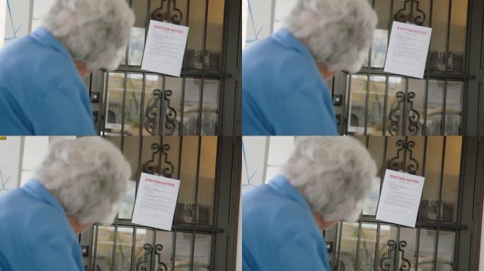 一位100岁的老年妇女站在家门口看着一张驱逐通知