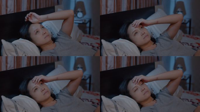 抑郁的亚洲女性无法在床上睡觉。失眠综合征
