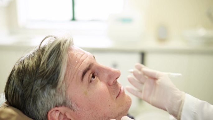 美容师在成熟男性患者脸上做肉毒杆菌注射标记