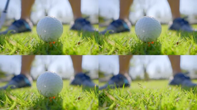 高尔夫球击球时，球打离发球台的特写镜头。高尔夫球杆以超慢动作击打高尔夫球，草地和球座上升到空中。早晨