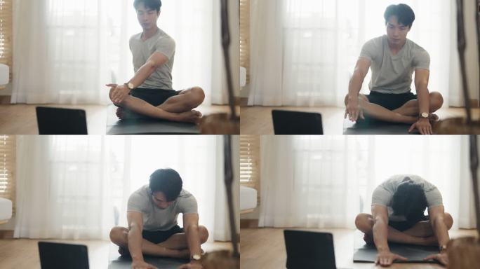 年轻人正在做瑜伽，看教程，在公寓的垫子上使用笔记本电脑