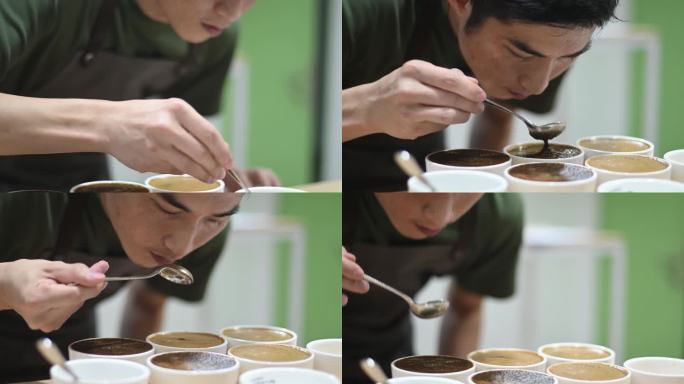 专业的亚裔中国男咖啡师，品酒师，正在进行咖啡杯的品酒，弯腰，闻每一杯咖啡，仔细品尝