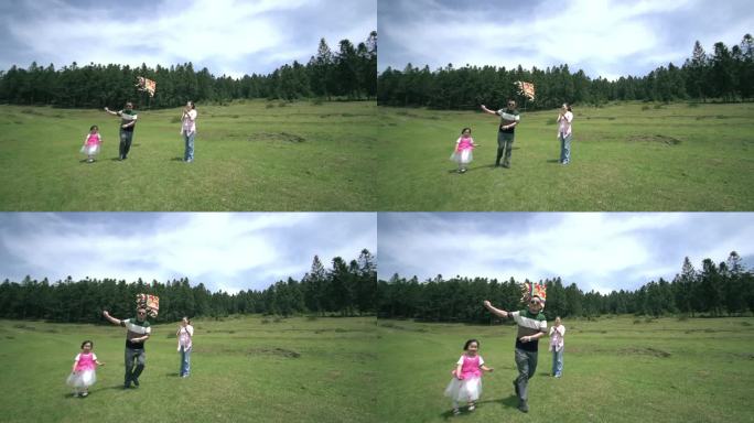 夫妻二人带小孩野外玩耍草坪放风筝近景03