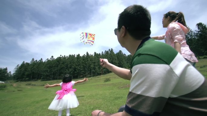 夫妻二人带小孩野外玩耍草坪放风筝近景02