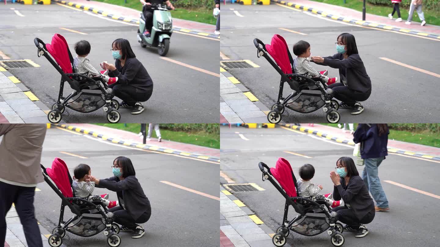 疫情防控下妈妈给婴儿车里的女儿戴口罩