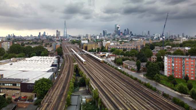繁忙的伦敦通勤列车与远处的城市天际线擦肩而过