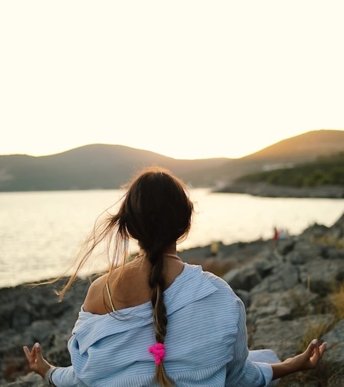 海边的一位年轻女子正在做瑜伽和冥想