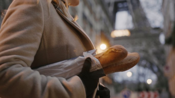 SLO-MO：一名法国妇女沿着埃菲尔铁塔沿街携带法式面包