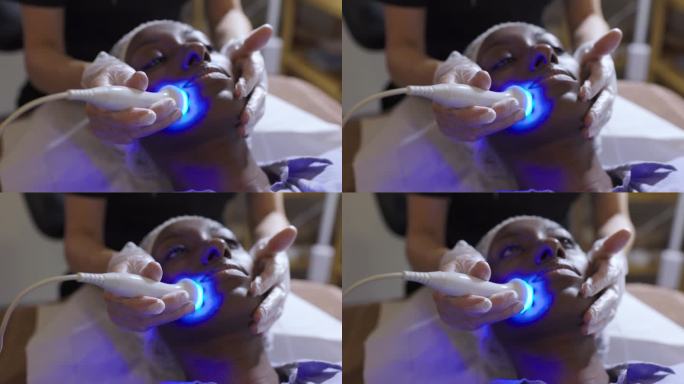 一位非洲裔美国妇女在水疗中心接受超声波和光疗法的面部恢复治疗
