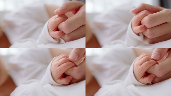 特写新生儿在家睡觉时握住母亲的手指。人寿保险、护理、保护