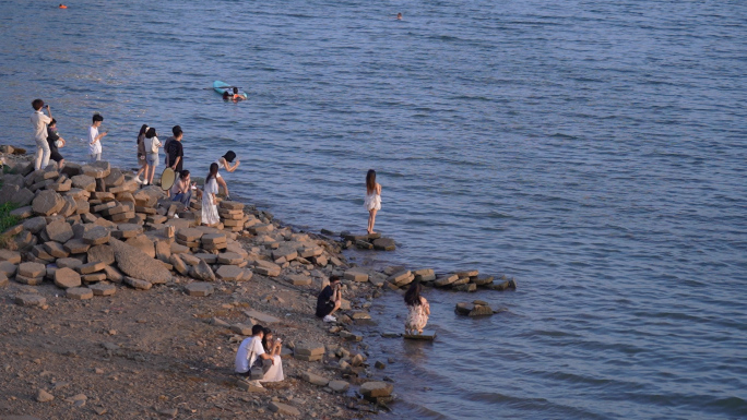 年轻的人们在水边拍照