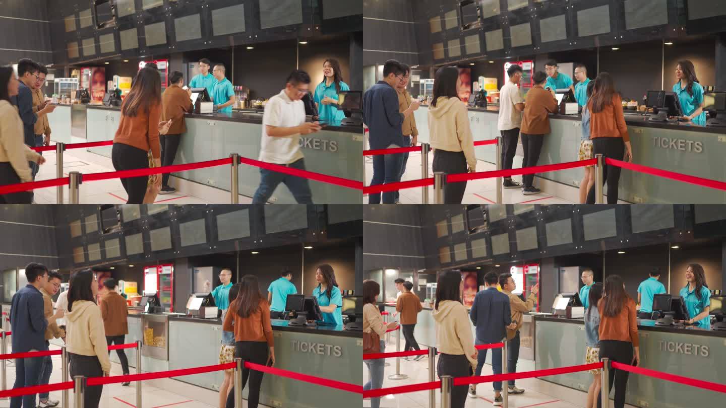 后视图：亚裔中国人群，人们在电影院排队购买电影票和快餐