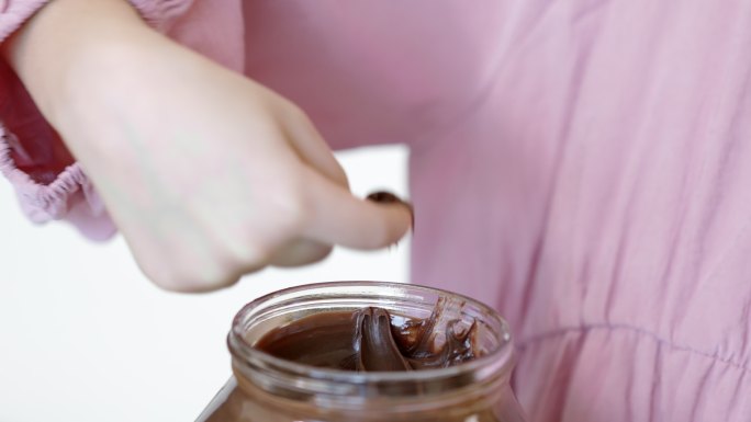 孩子用手指蘸巧克力奶油，用手指吃巧克力