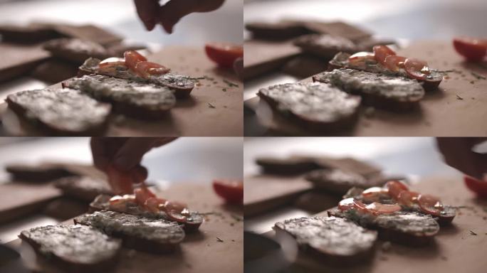厨师在三明治上添加番茄片的选择性聚焦镜头