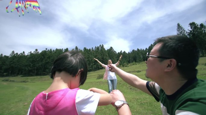 夫妻二人带小孩野外玩耍草坪放风筝近景01
