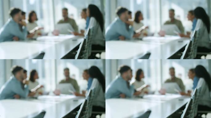 在商业演示或研讨会上，团队在董事会会议桌上工作的散焦照片。