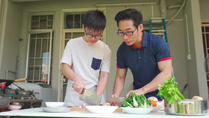 周末，亚裔中国父子在家后院潮湿的厨房做饭，为家人准备晚餐