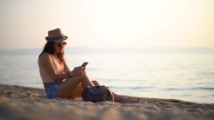 海滩上的女人在智能手机上发短信