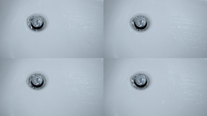 特写：白色浴缸的水槽塞中有水