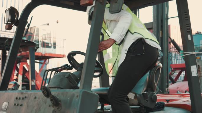 女性码头工人在装运港驾驶叉车。