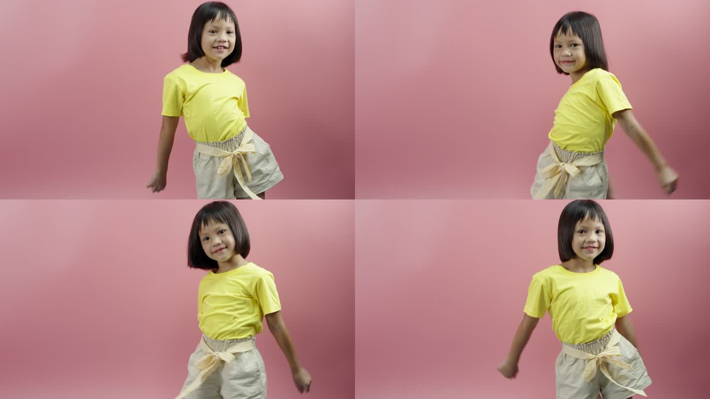 小女孩在粉红色背景下听音乐跳舞。