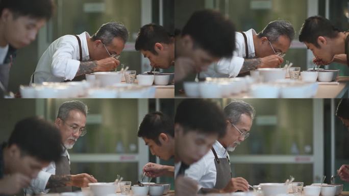 专业的亚洲华人高级男咖啡师，咖啡鉴赏家，表演咖啡杯，用勺子品尝咖啡杯