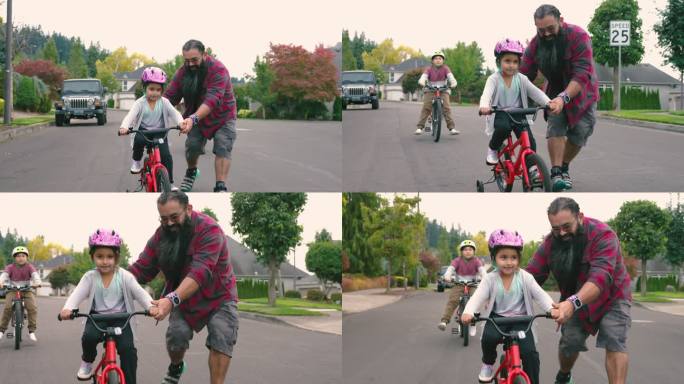 一位美国原住民父亲正在帮助他的小女儿学习骑自行车