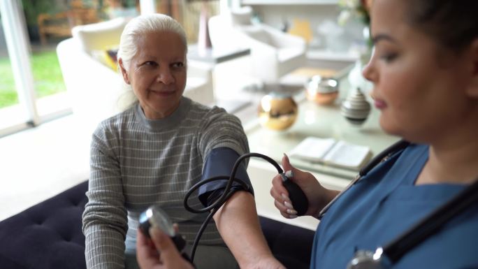 护士在家给一位老年病人测血压