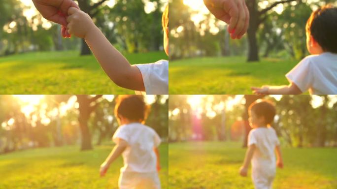 HD：一个男孩牵着妈妈的手在公园里跑步。
