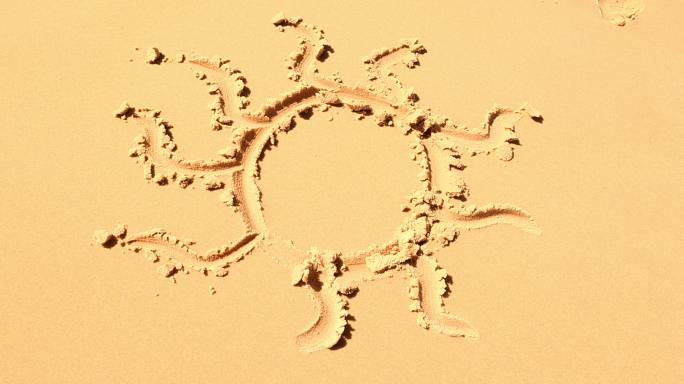 假期天气。沙滩上的阳光符号被海水冲走。