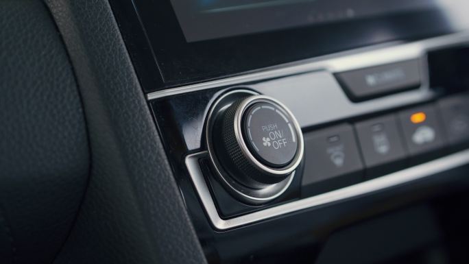 按下按钮打开汽车空调的特写镜头。