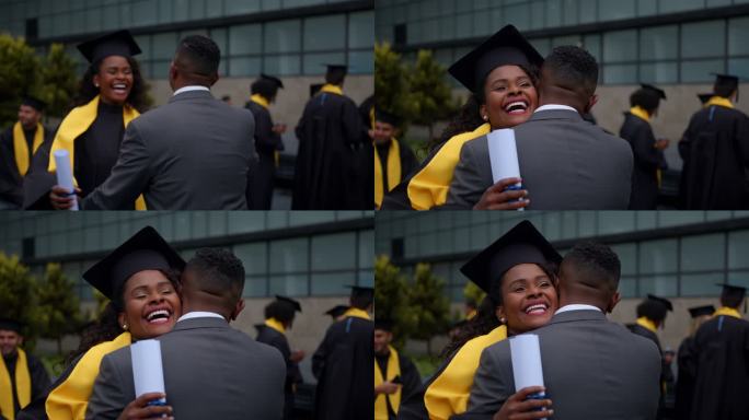快乐的非裔美国研究生在毕业日抱着毕业证书拥抱父亲