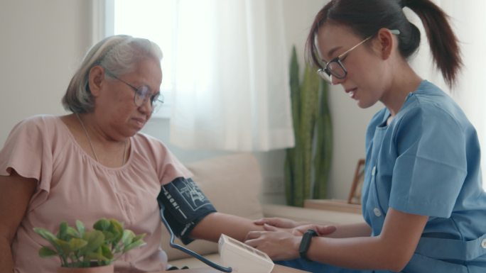 女医生正在为一位老年患者检查血压。