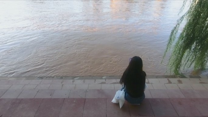 黄河河边孤独坐着的女性
