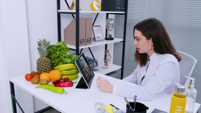 营养师使用数字平板电脑与患者进行在线咨询