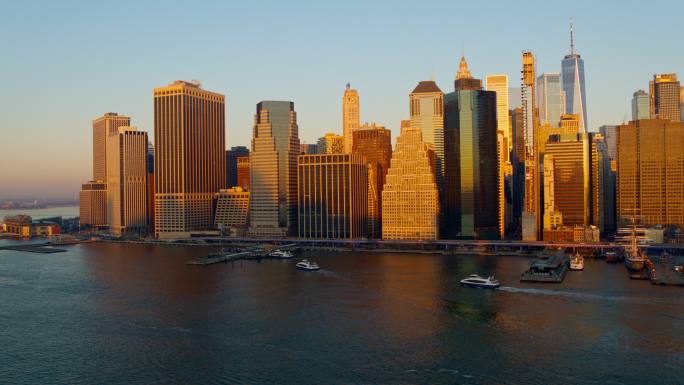 从空中俯瞰曼哈顿市中心的滨水区，渡轮在清晨抵达和离开东河上的华尔街11号码头。无人机视频与平移摄像机