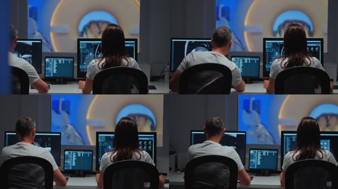 两名MRI放射科医生坐在控制室操作MRI扫描仪