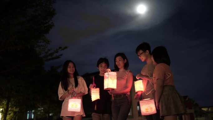 亚裔华人母亲带着孩子和侄子手持纸灯笼，庆祝中秋节。