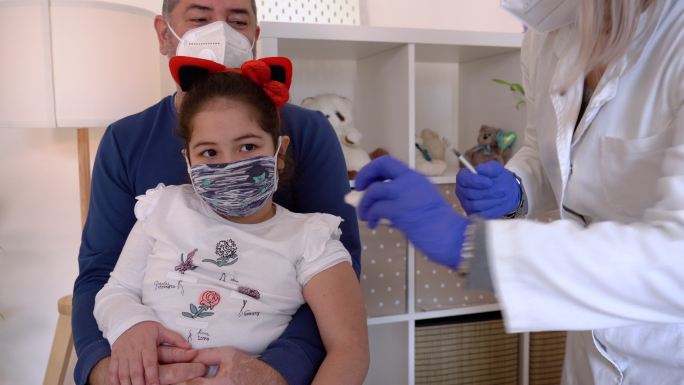 女孩接种新冠疫苗戴口罩看病治疗给小孩打针